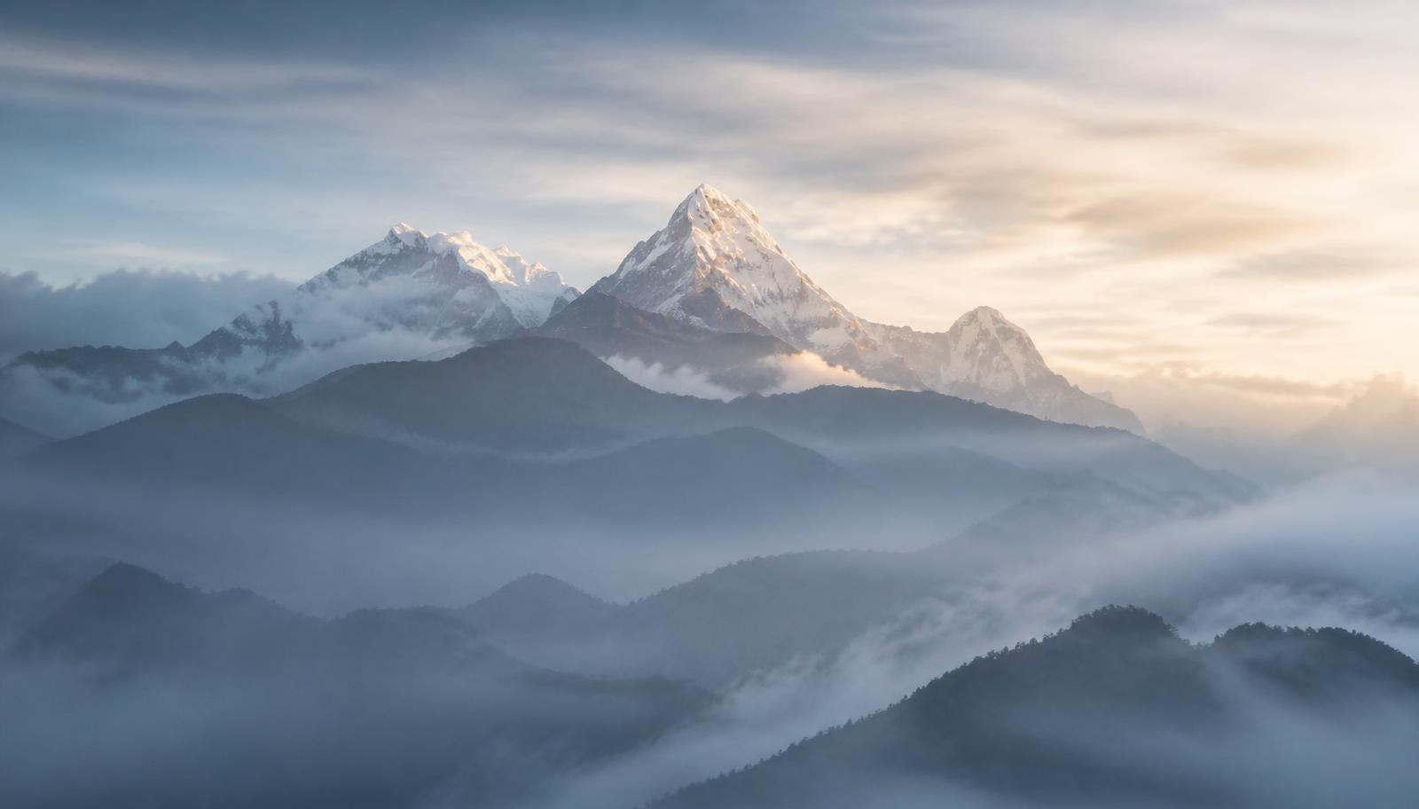 Layered Himalayan ridges at dawn with mist drifting between peaks